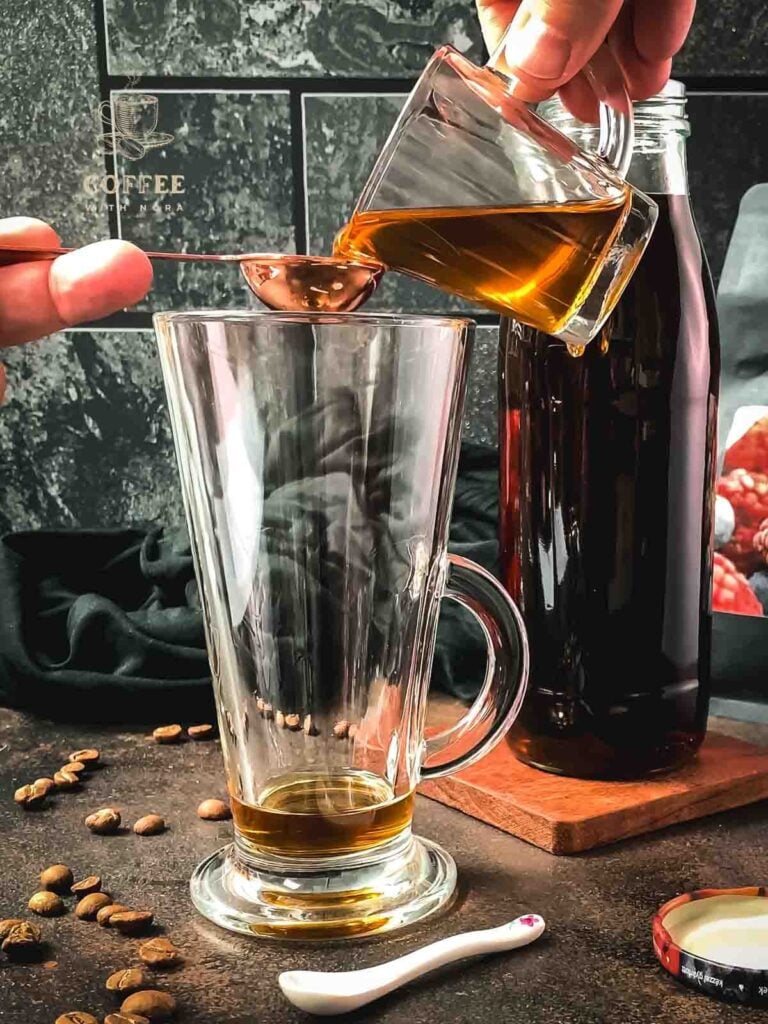 Measure homemade coffee syrup into a serving glass.