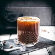 Stunning and delicious iced Americano, served in a gorgeous glass and placed on a black slate plate.