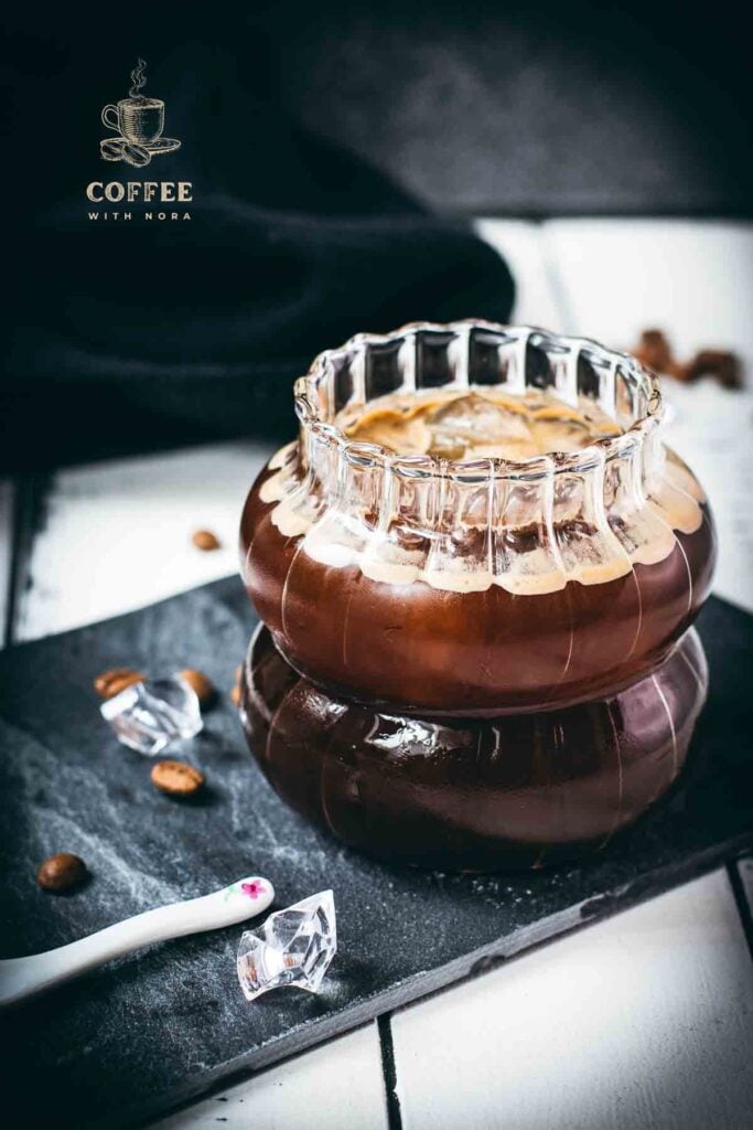 Stunning and delicious iced Americano, served in a gorgeous glass and placed on a black slate plate.