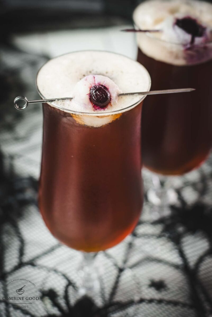 Spooky black velvet cocktail, garnished with eerie lychee eyeballs.