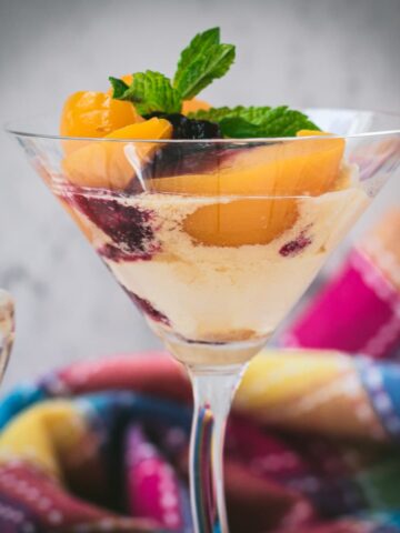 Elegant peach melba, served in cocktail glass.