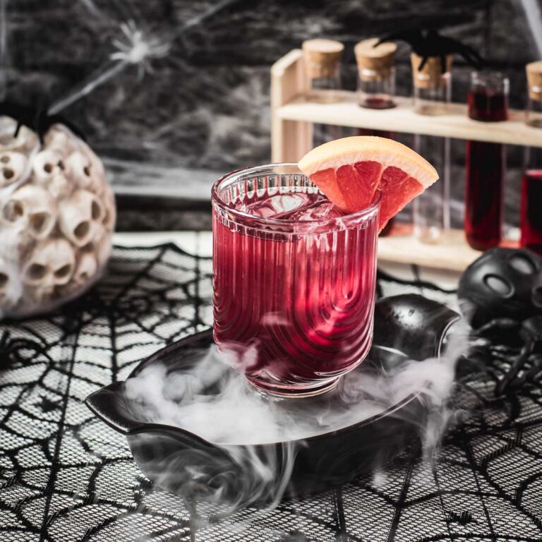 Spooky bloody sea breeze cocktail, served in a beautiful glass. Placed in a smoking black bowl.