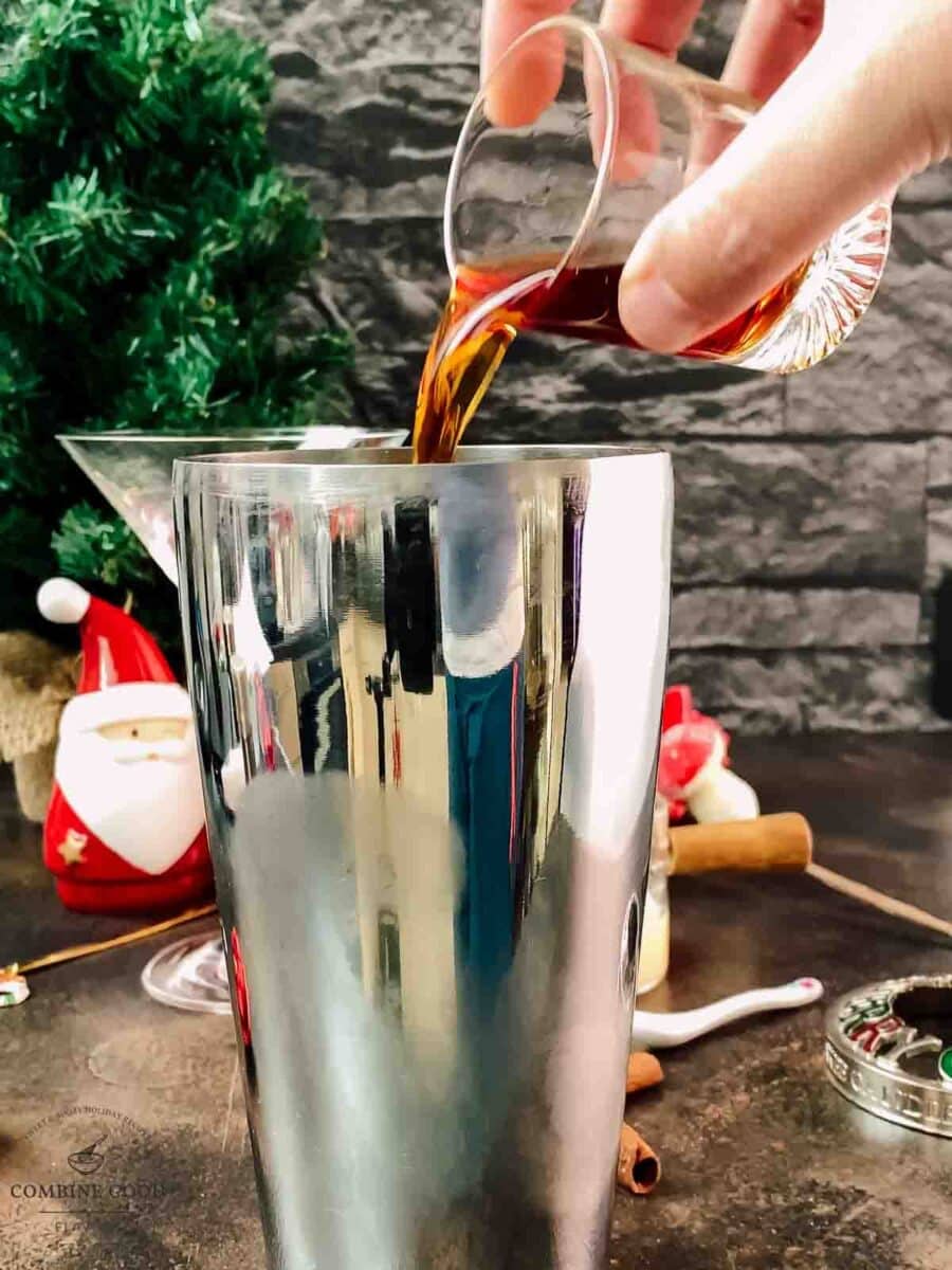 Add spiced rum to the cocktail shaker.