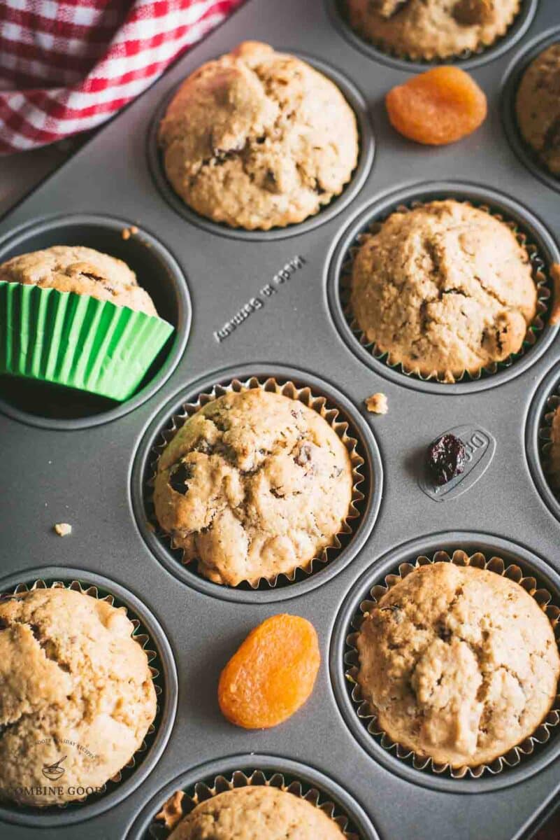 cute fruit and nut muffins with colored lines, still in muffin pan.