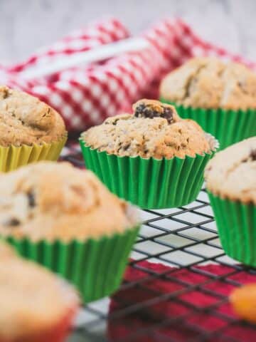 cute fruit and nut muffins with colored lines, placed on cooling rack.