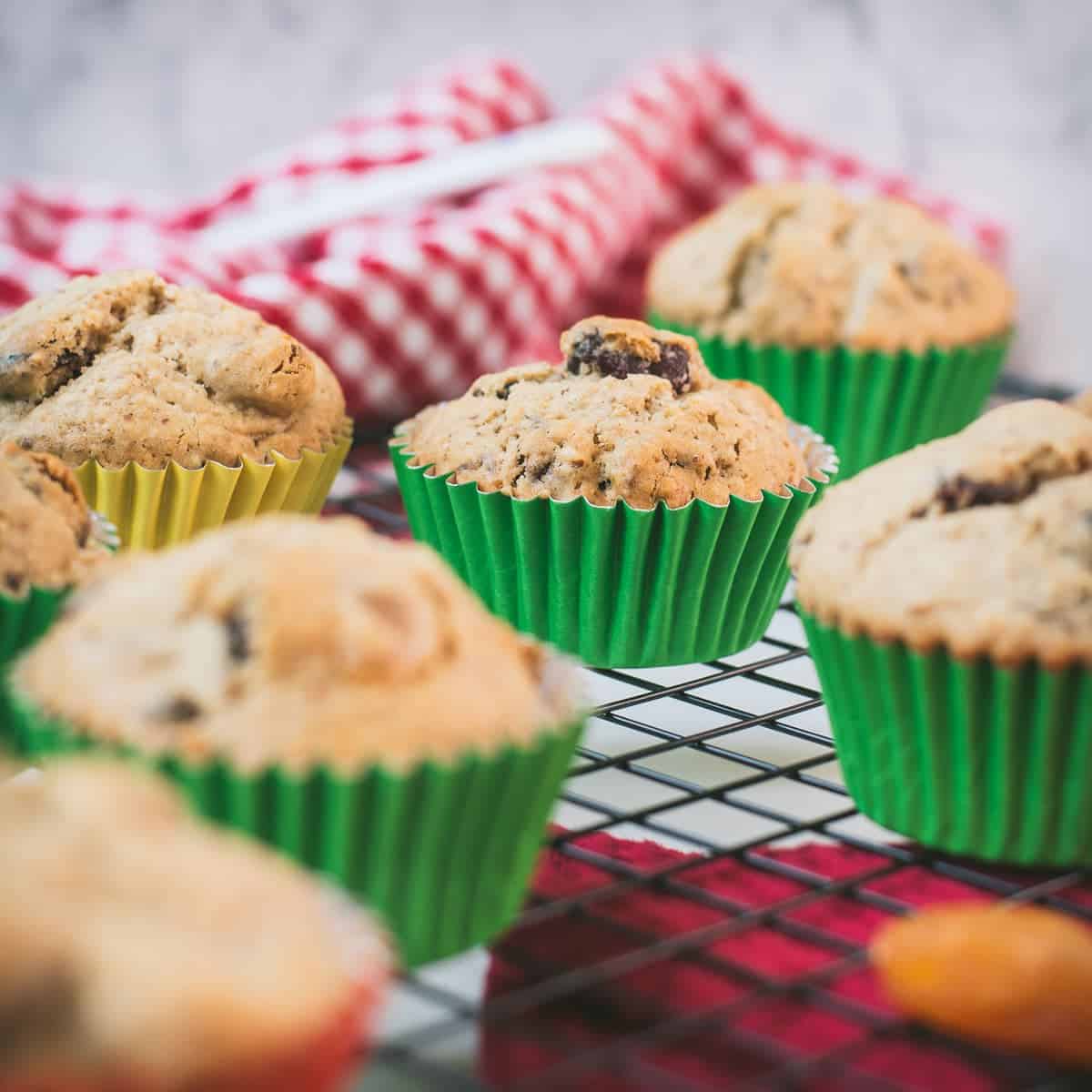 cute fruit and nut muffins with colored lines, placed on cooling rack.