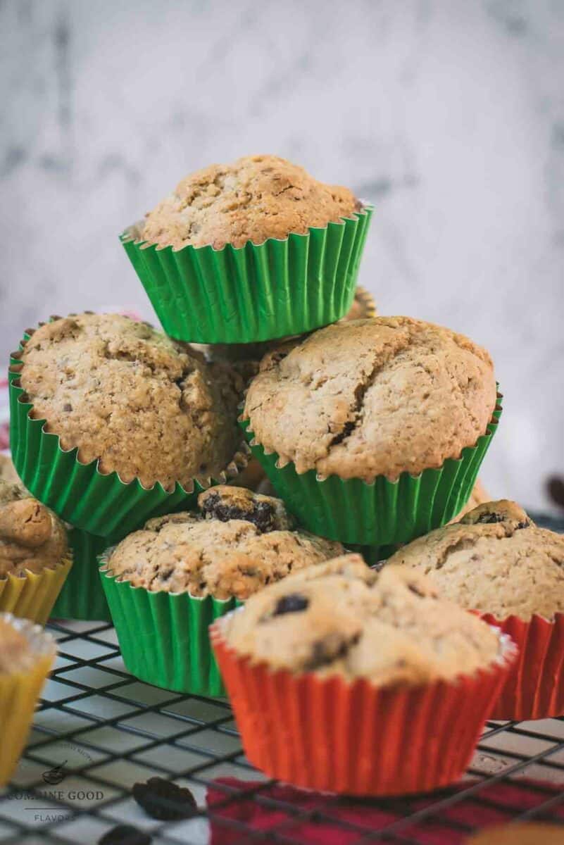 cute fruit and nut muffins with colored lines, stacked on cooling rack.