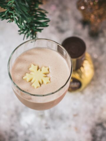 Divine rum alexander cocktail, garnished with a white chocolate snowflake.