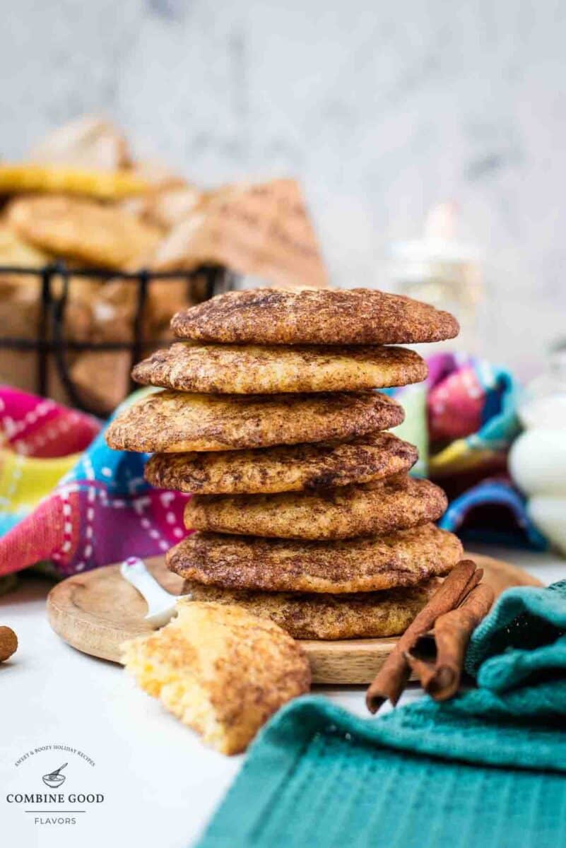 Fluffy snickerdoodle cookies stacked on wooden plate.