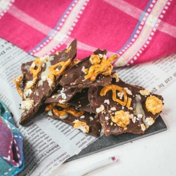 Delicious salted caramel popcorn bark placed on black slate.