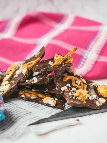 Delicious salted caramel popcorn bark placed on black slate.