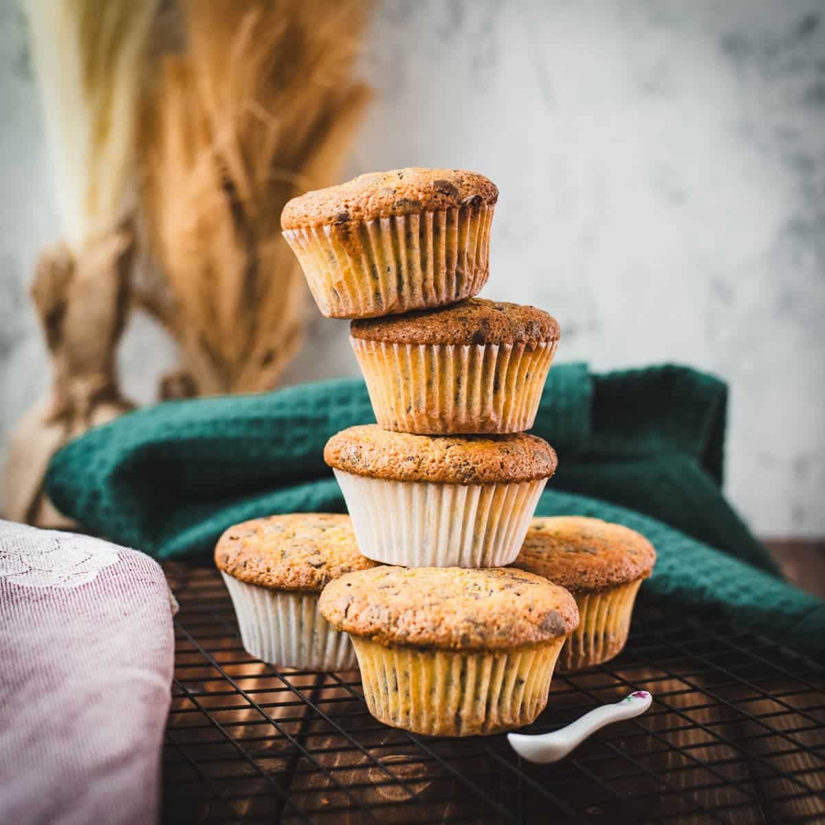 Delicious 4 egg yolk chocolate chip muffins stacked on cooling rack.