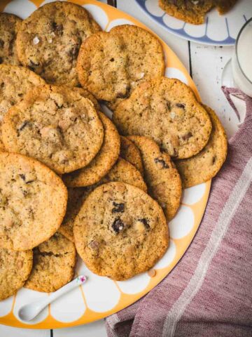 Divine salted caramel chocolate chip cookies, served on colorful platter.