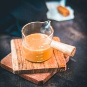 Measuring glass filled with caramel sauce.