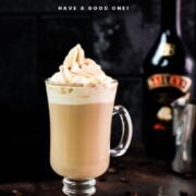 Decadent Bailey'S coffee, served in beautiful glass, placed on dark ground and topped with delicious whipped cream.