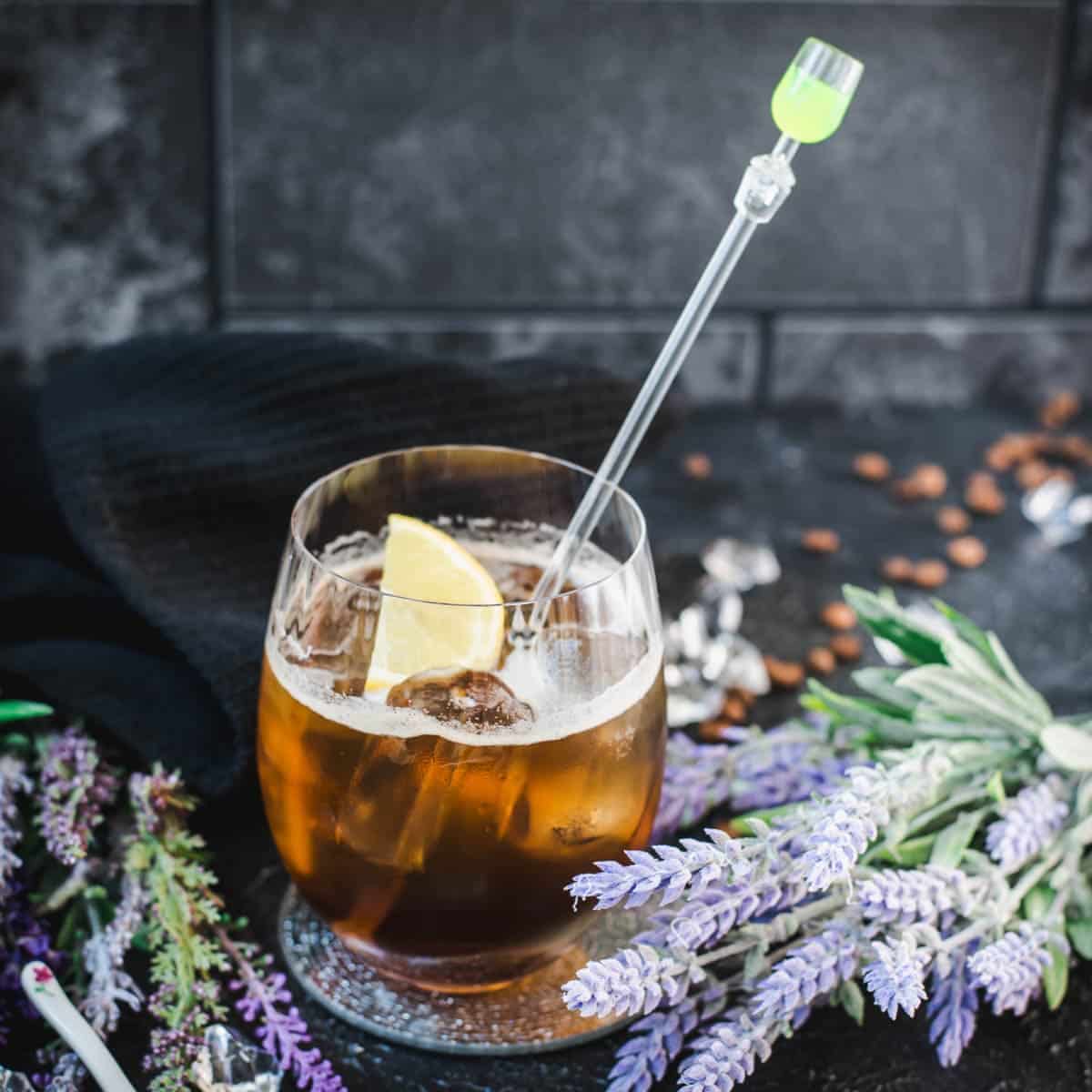 Delicious lavender cold brew cocktail with tonic water and vodka. Served in an gin tonic glass and garnished with a lemon slice.