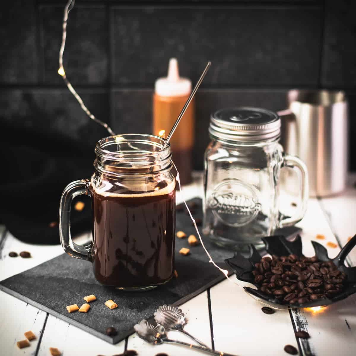 Delicious caramel coffee, placed on black slate plate and served with a reusable drinking straw.
