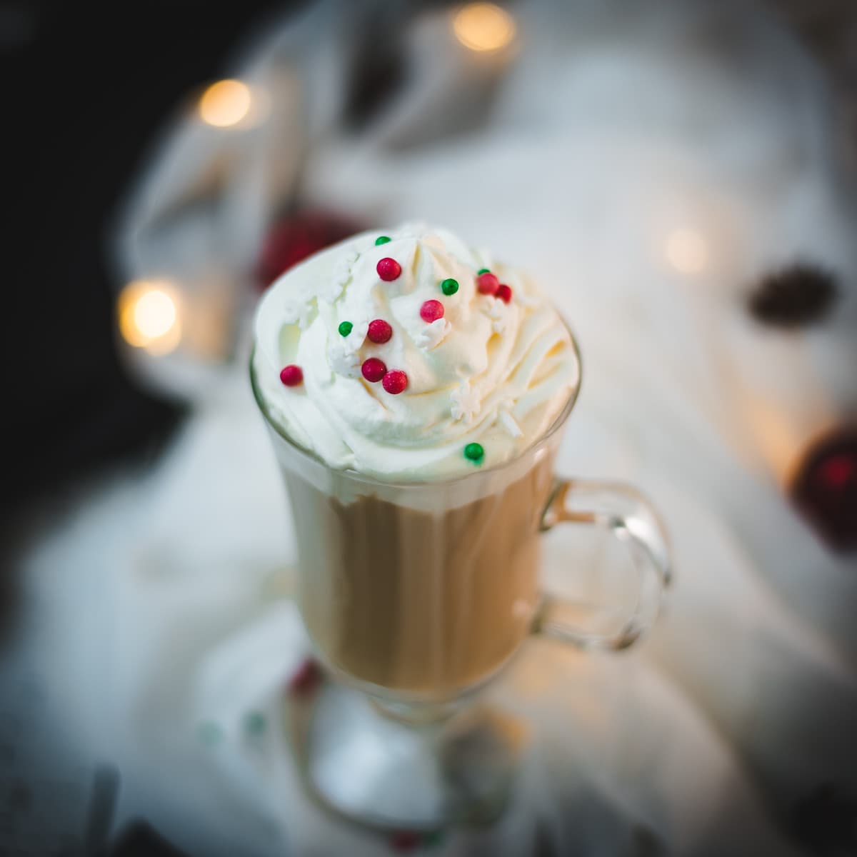 Christmas coffee made with delicious Christmas coffee creamer served in gorgeous glass and served with red and green sprinkles.