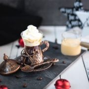 Delightful coffee with eggnog whipped cream topping served in medieval glass mugs.