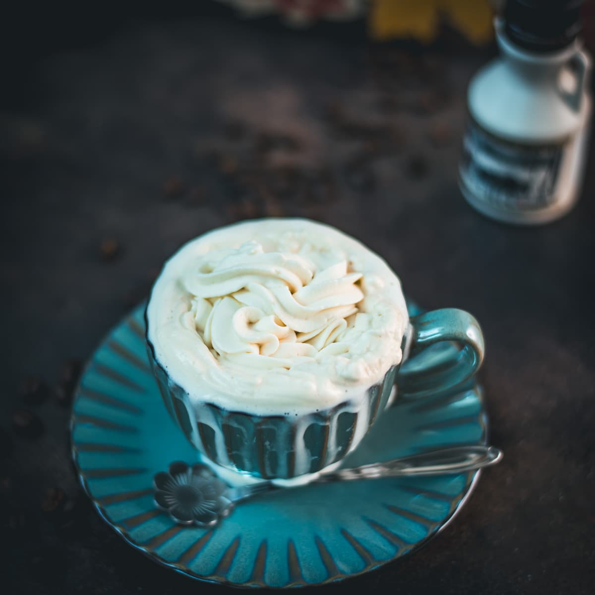 Delicious maple whipped cream topping, served on top of a coffee in a teal colored mug.