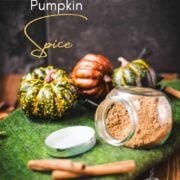 Spice jar filled with homemade pumpkin spice, placed on green felt mat.