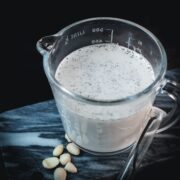 Delicious plant based vanilla milk in serving jug. Placed on marbled plate.