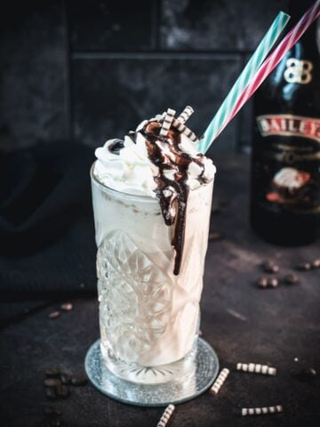 Decadent Bailey's iced coffee, topped with whipped cream and drizzled with chocolate sauce and chocolate zebra rolls.