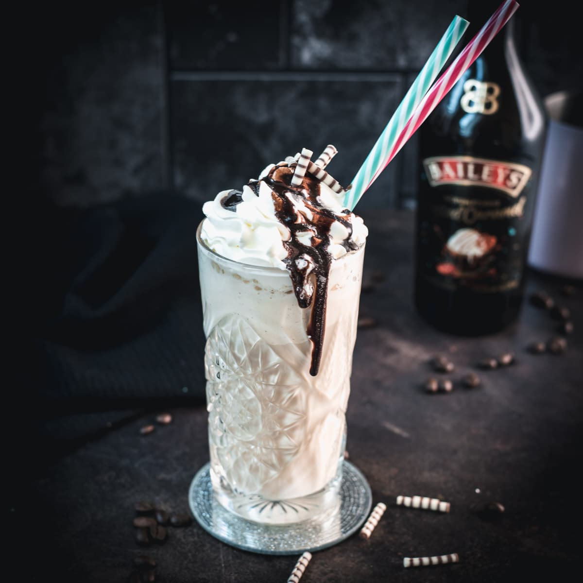 Decadent Bailey's iced coffee, topped with whipped cream and drizzled with chocolate sauce and chocolate zebra rolls.