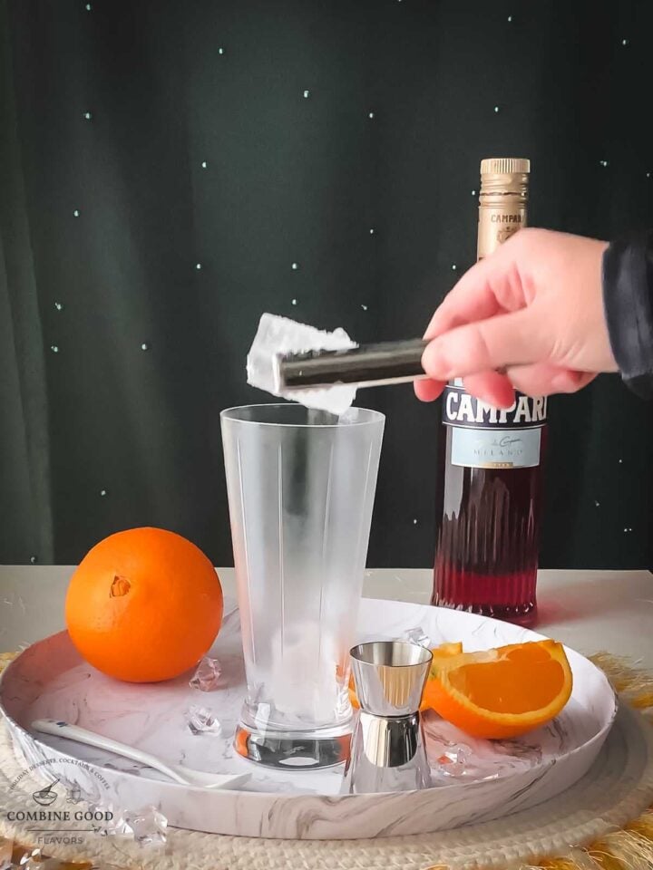 Add cubed ice to the chilled serving glass.