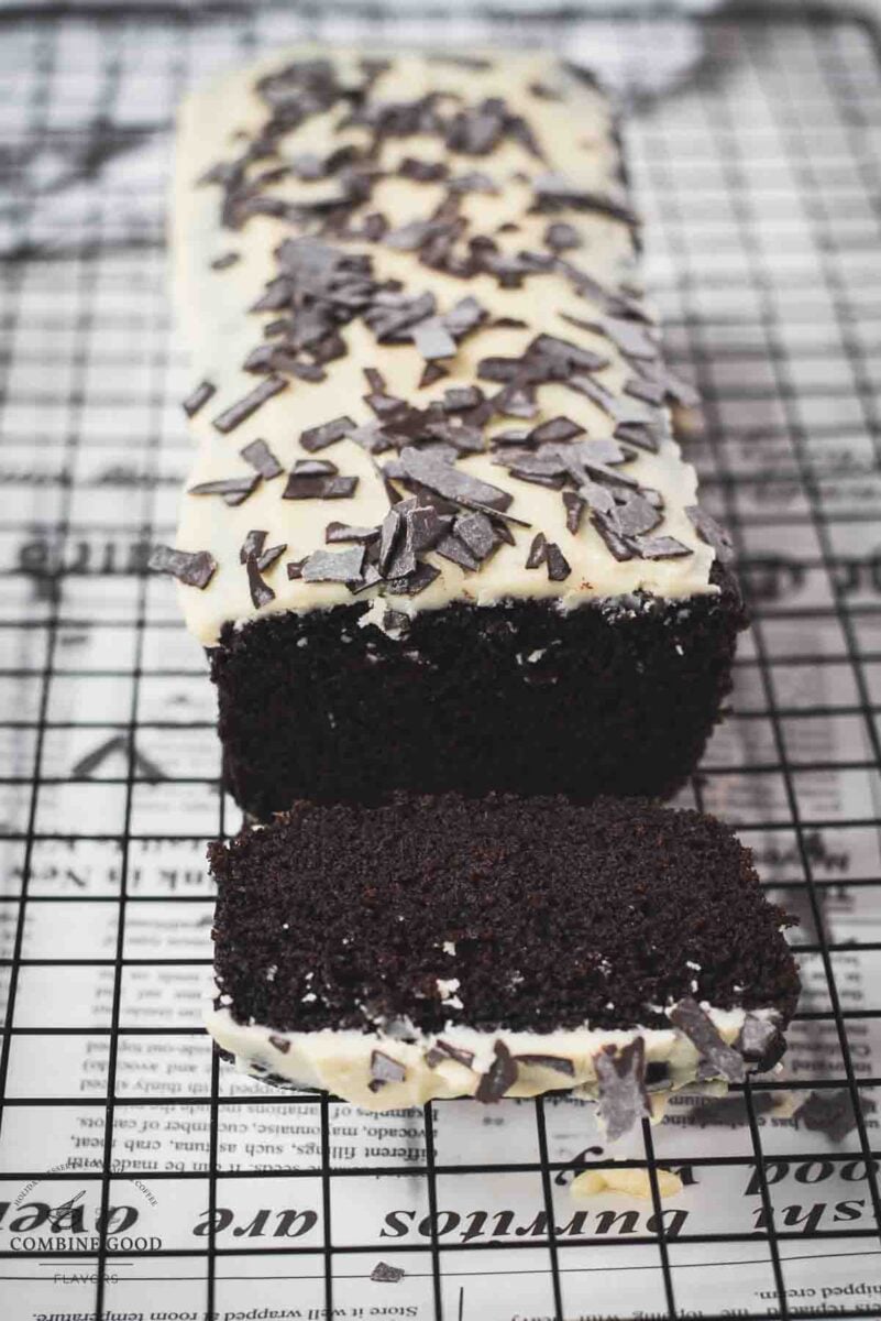 Divine chocolate buttermilk loaf cake with white chocolate frosting, sprinkled with chocolate shavings.