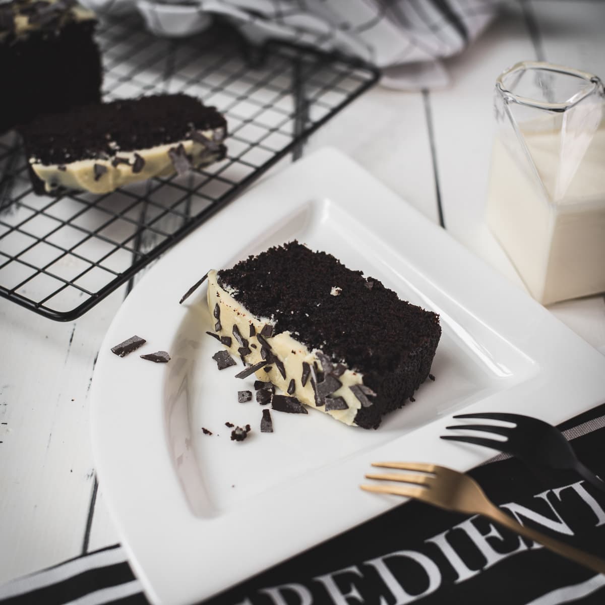 Divine chocolate buttermilk loaf cake with white chocolate frosting, sprinkled with chocolate shavings.