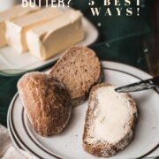 Buttered bread placed on a white plate with a brown rim.