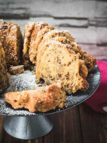 Delicious vanilla bundt cake with chocolate sprinkles, served on light blue cake stand.