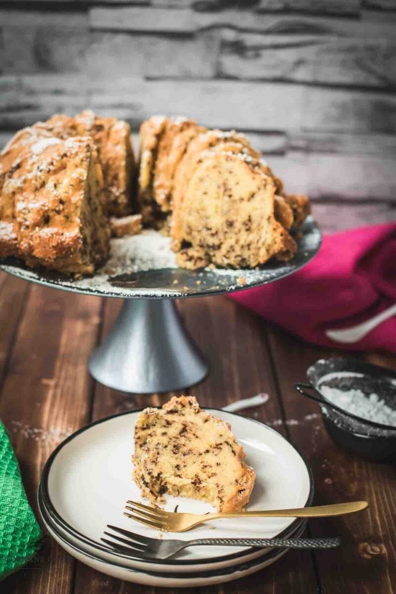 Delicious vanilla bundt cake with chocolate sprinkles, served on light blue cake stand.