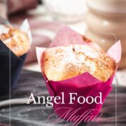 Cute angel food muffins, dusted with powdered sugar, placed on marbled plate and served with a delicious cafe latte.