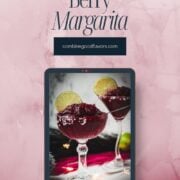 Magnificent frozen mixed berry margarita, served in cocktail glasses, garnished with a lime slice. With a vibrant dark red color. What an eye-catcher!