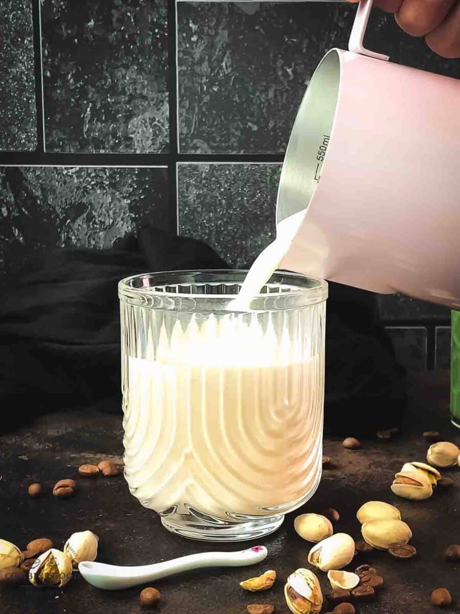 Pour frothed milk on top of the pistachio liqueur espresso mixture.