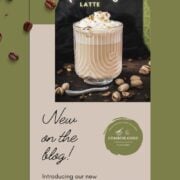 Divine pistachio latte with pistachio liqueur, served in beautiful drinking glass, resting on dark surface scattered with coffee beans and pistachios.