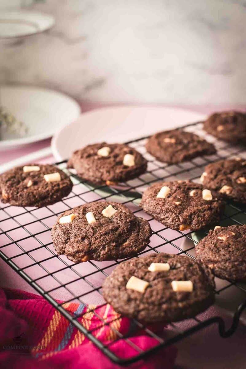 Divine white chocolate chip cookies with an incredible dark chocolate dough. Placed on a cooling rack.