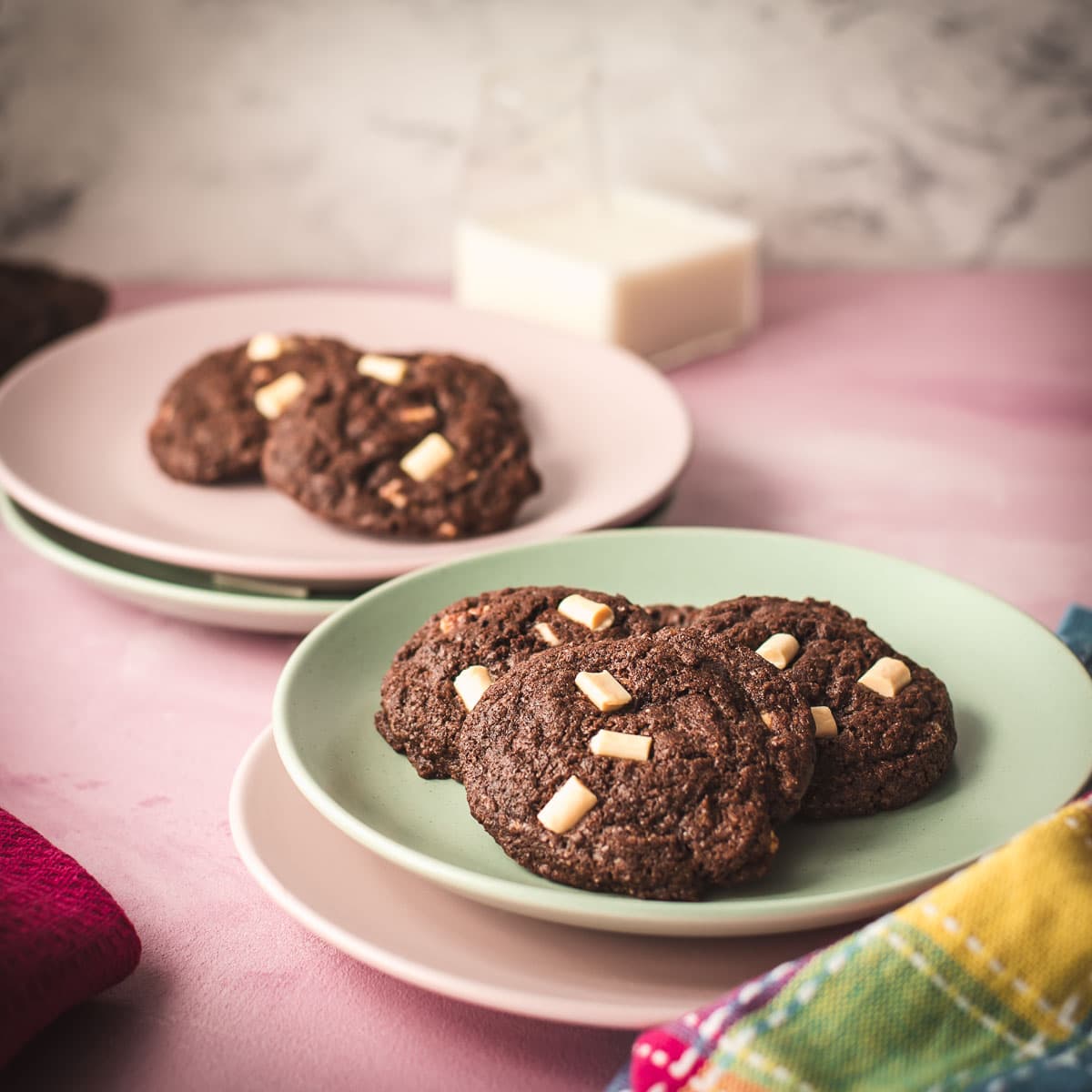 Divine white chocolate chip cookies with an incredible dark chocolate dough. Placed on pink-green plates.