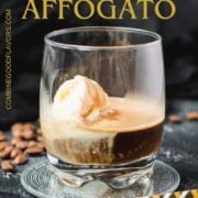 A scoop of vanilla ice cream sits in a glass of dark espresso on a black surface, making a perfect affogato.