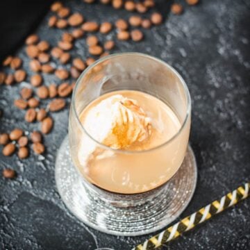 This photo shows a glass with an affogato, featuring a scoop of vanilla ice cream floating in espresso.