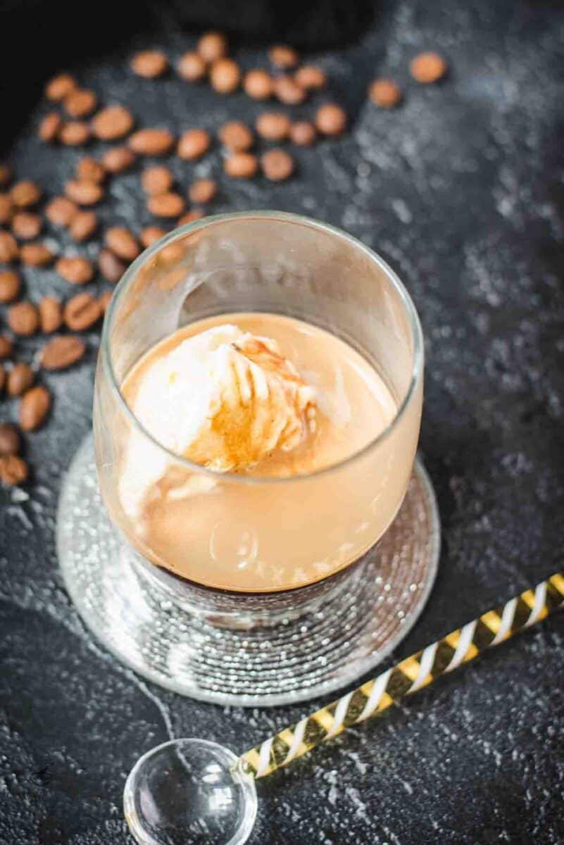This photo shows a glass with an affogato, featuring a scoop of vanilla ice cream floating in espresso.