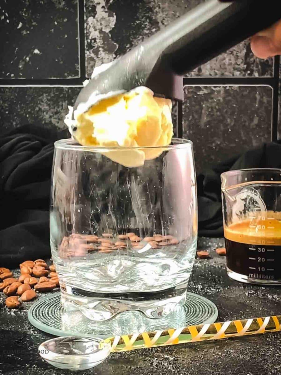 Scoop one scoop of vanilla ice cream into your serving glass.
