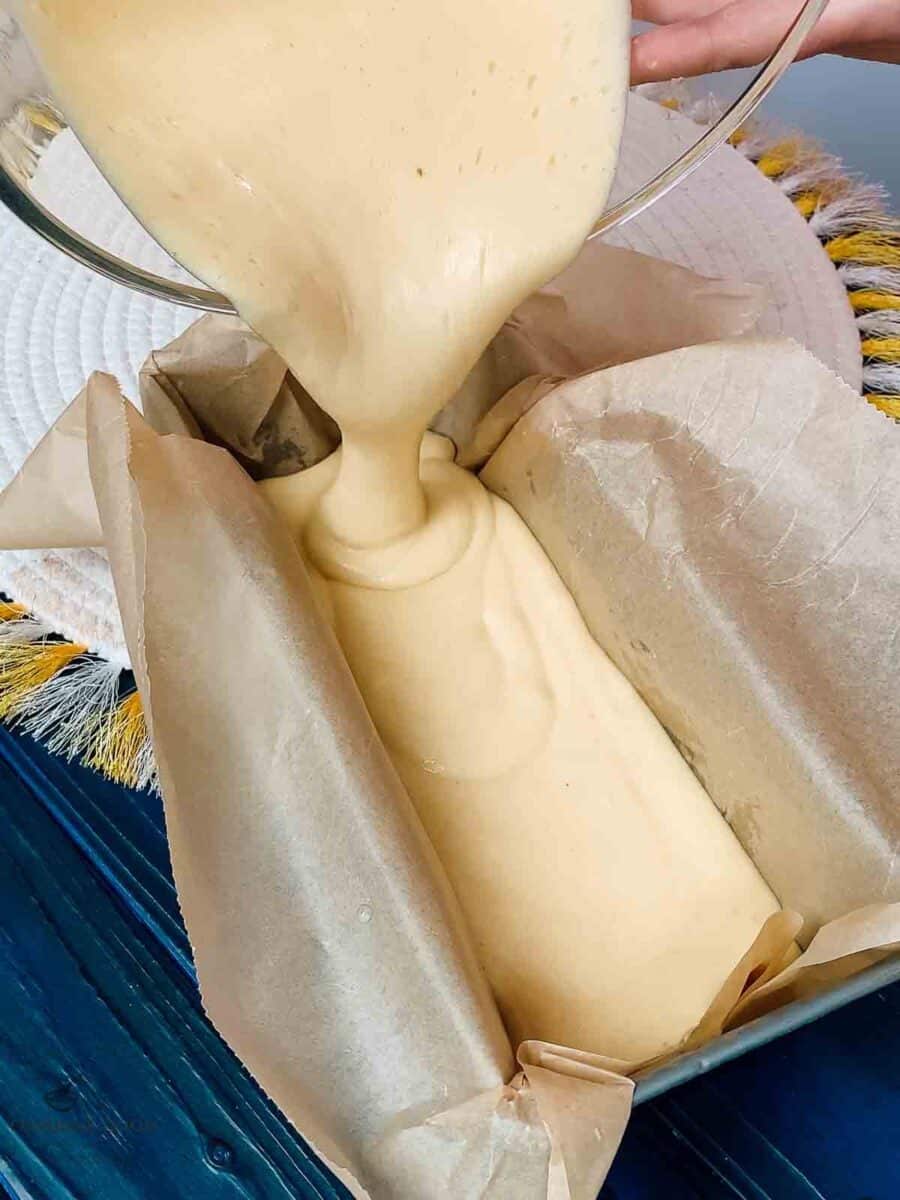 Pouring the lemon loaf cake better into the prepared loaf pan.
