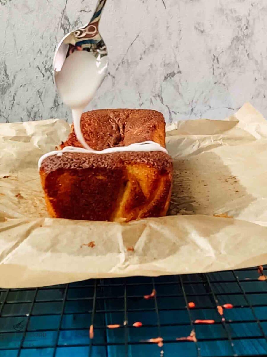 Drizzling homemade lemon glaze over the freshly baked lemon loaf cake.