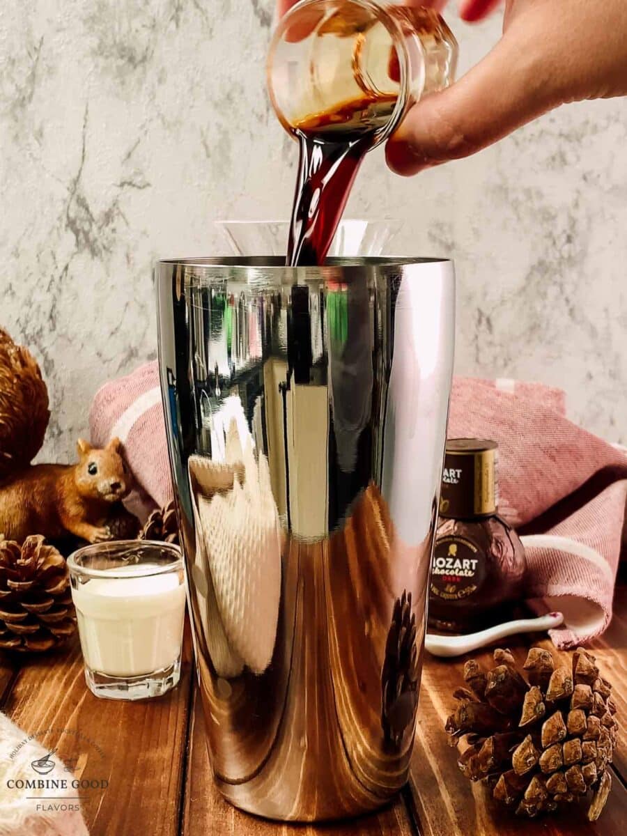 Adding Mozart Dark Chocolate Liqueur to the cocktail shaker