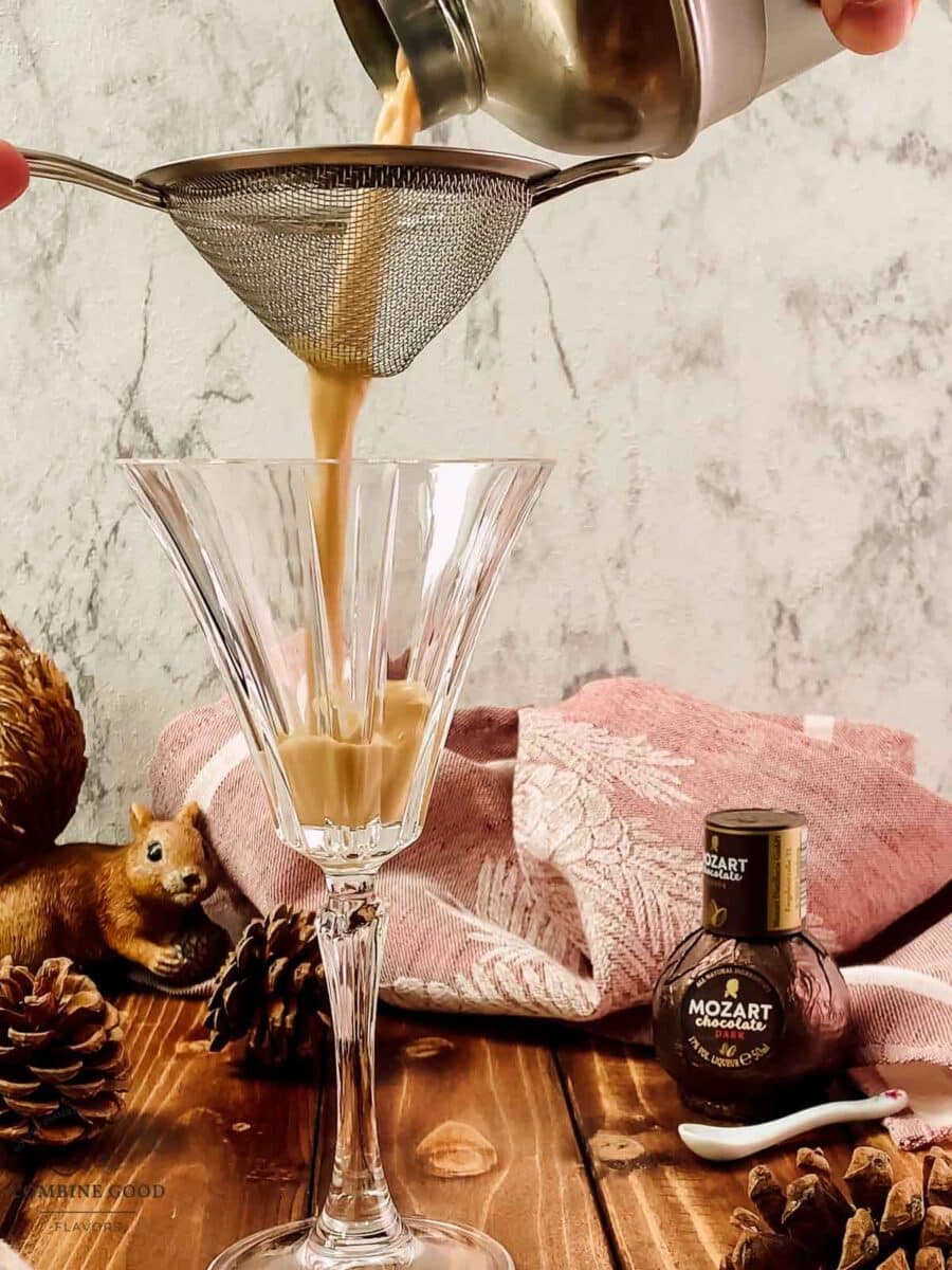Straining a Brandy Alexander into a chilled cocktail glass