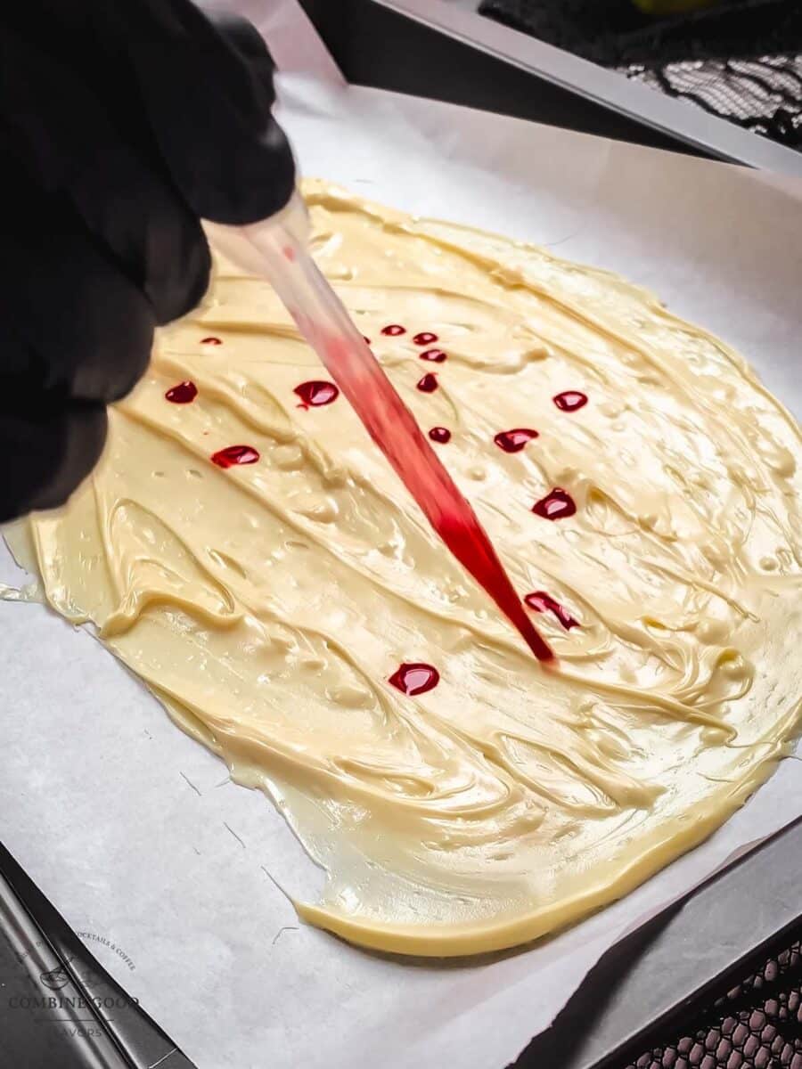 Drop some berry blood syrup on top of the spread melted chocolate.
