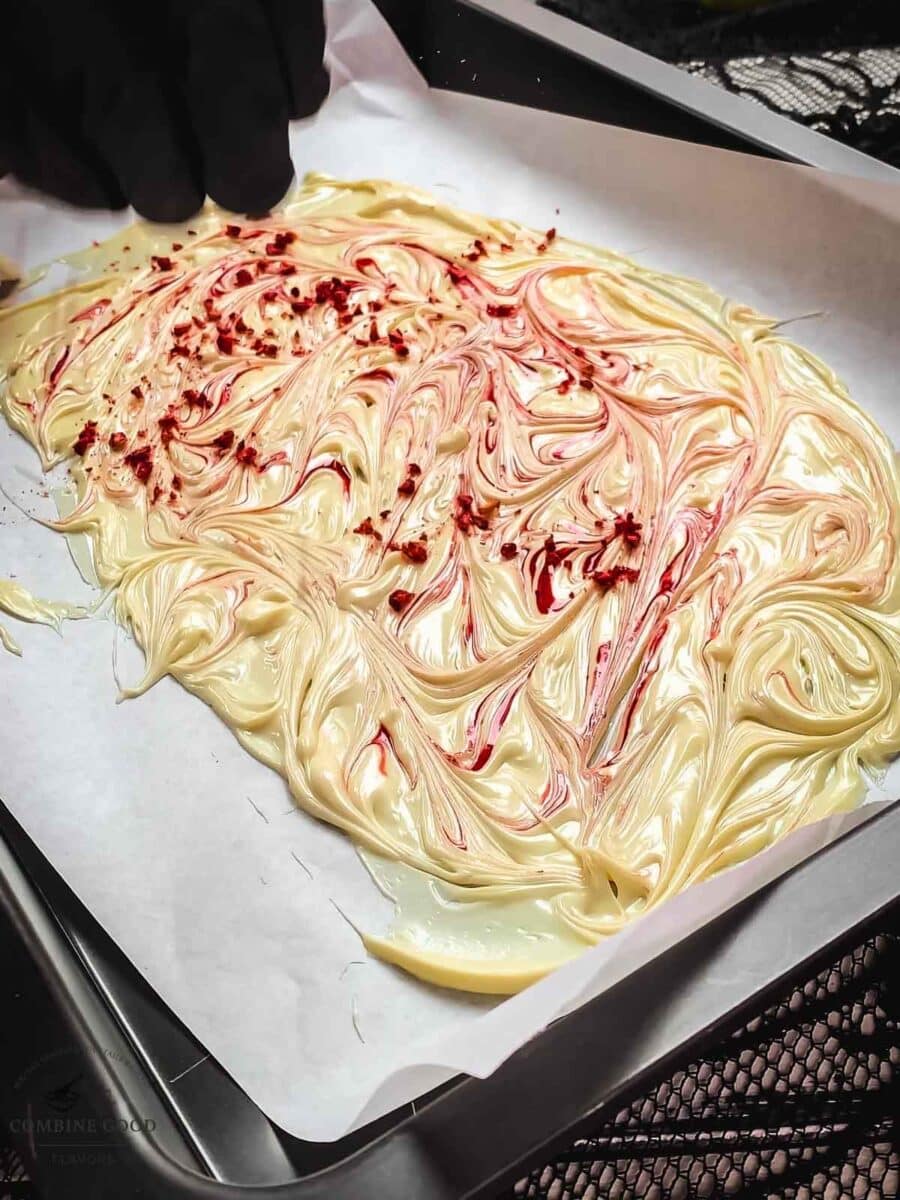 Sprinkle crushed freezer dried raspberries on top of the white chocolate.